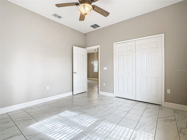 unfurnished bedroom with ceiling fan and a closet