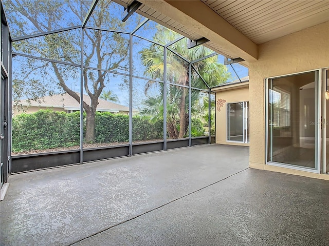 unfurnished sunroom featuring beam ceiling