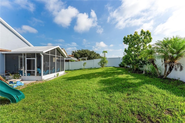 view of yard featuring a playground and a sunroom