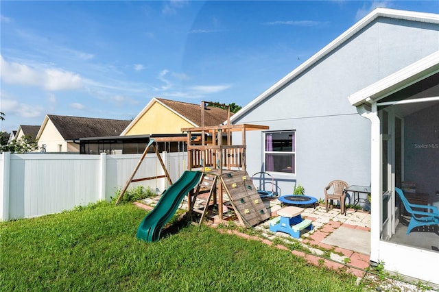 view of playground featuring a patio and a lawn