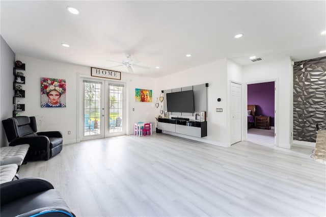 living room featuring ceiling fan, light hardwood / wood-style flooring, and french doors