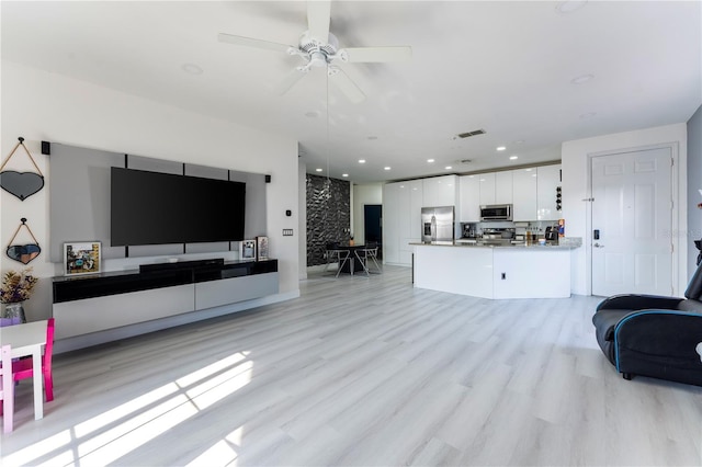 living room with ceiling fan and light hardwood / wood-style floors