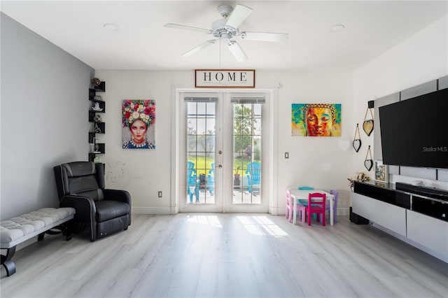 living area featuring ceiling fan, french doors, and light hardwood / wood-style floors