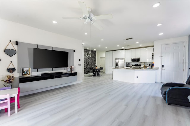 living room with light hardwood / wood-style floors and ceiling fan