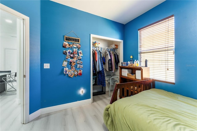 bedroom with a walk in closet, a closet, and hardwood / wood-style flooring