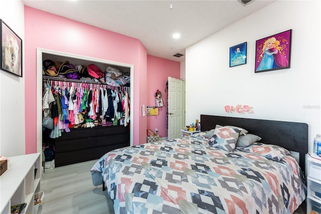 bedroom with light wood-type flooring and a closet