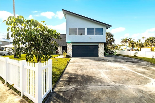 contemporary house featuring a front yard and a garage