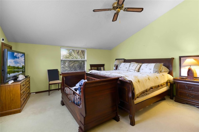 bedroom with ceiling fan, lofted ceiling, and light carpet