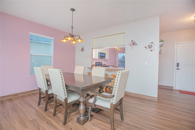 dining area featuring a notable chandelier and light hardwood / wood-style floors