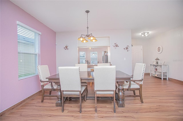 dining space featuring a wealth of natural light, hardwood / wood-style floors, and a chandelier