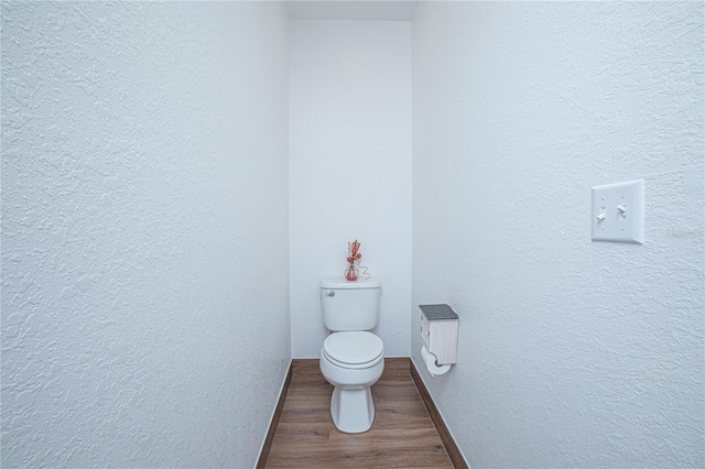 bathroom featuring hardwood / wood-style floors and toilet