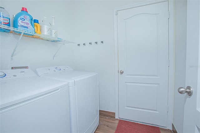 washroom featuring washing machine and clothes dryer and light hardwood / wood-style floors