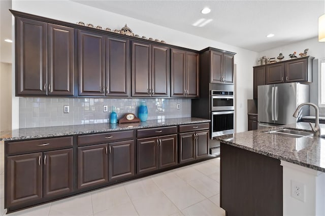 kitchen with dark brown cabinetry, sink, appliances with stainless steel finishes, and tasteful backsplash