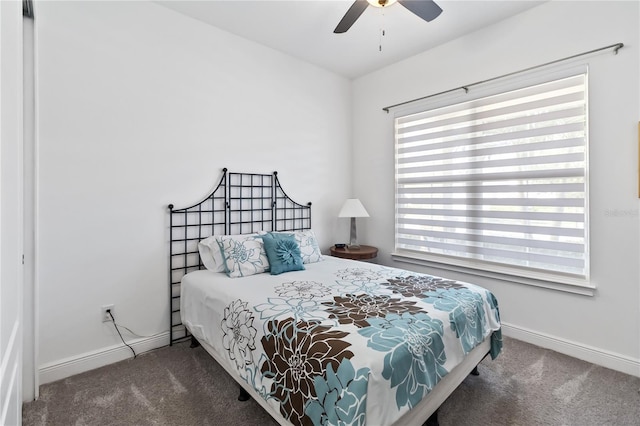 bedroom featuring multiple windows, ceiling fan, and dark colored carpet