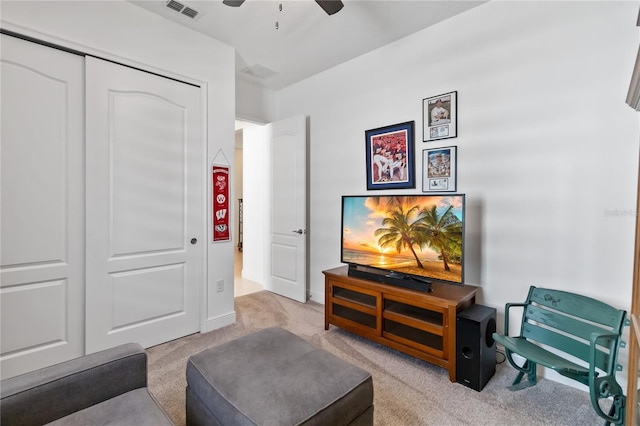 living area featuring light colored carpet and ceiling fan