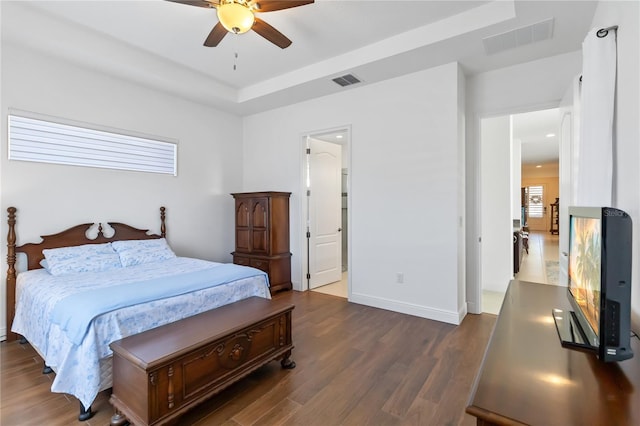 bedroom with ensuite bathroom, ceiling fan, and dark wood-type flooring