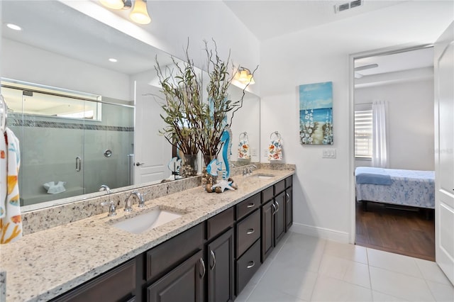 bathroom with tile patterned flooring, vanity, and walk in shower