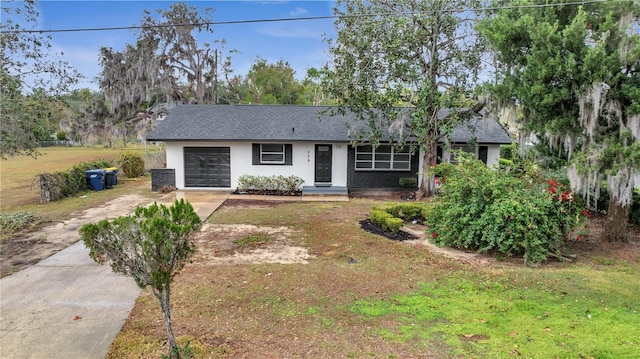 single story home with a garage and a front lawn