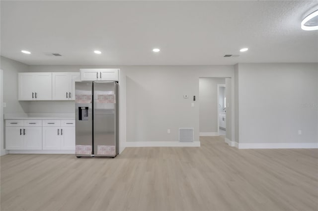 kitchen with white cabinets, light hardwood / wood-style floors, and stainless steel refrigerator with ice dispenser