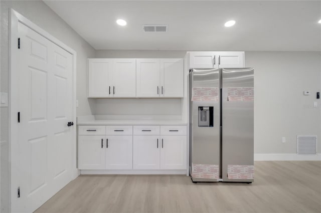 kitchen featuring white cabinets, stainless steel fridge with ice dispenser, and light wood-type flooring