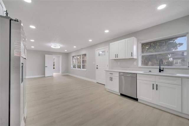 kitchen featuring sink, white cabinets, light hardwood / wood-style floors, and appliances with stainless steel finishes