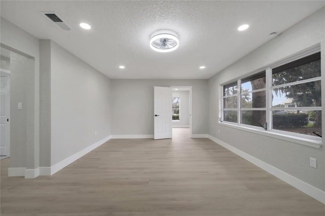 empty room featuring light hardwood / wood-style floors and a textured ceiling