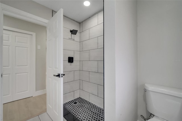 bathroom featuring toilet and a tile shower