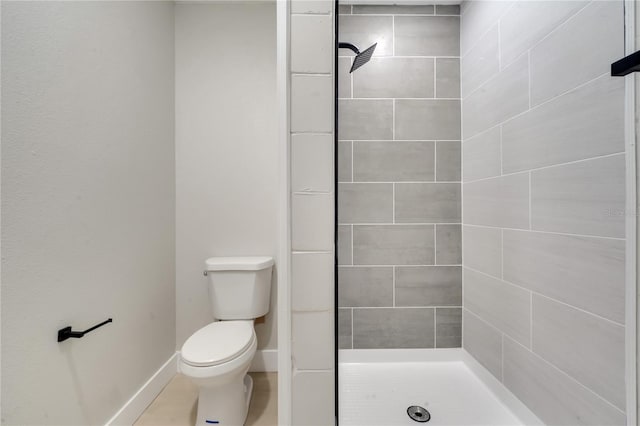 bathroom with tiled shower and toilet