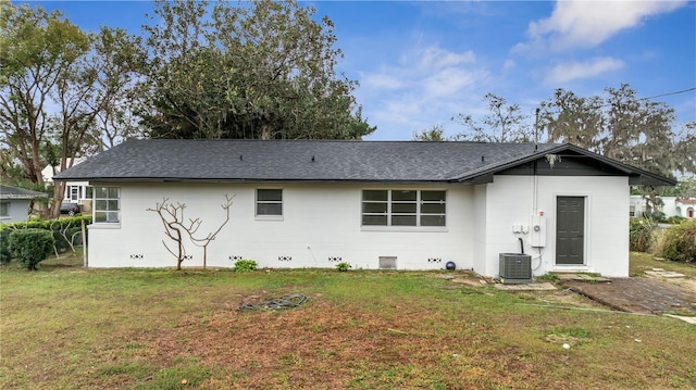 back of house with a lawn and central air condition unit