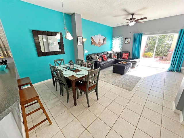 tiled dining space with a textured ceiling and ceiling fan with notable chandelier