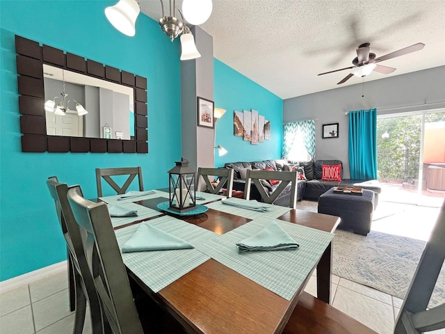 tiled dining room with ceiling fan with notable chandelier and a textured ceiling