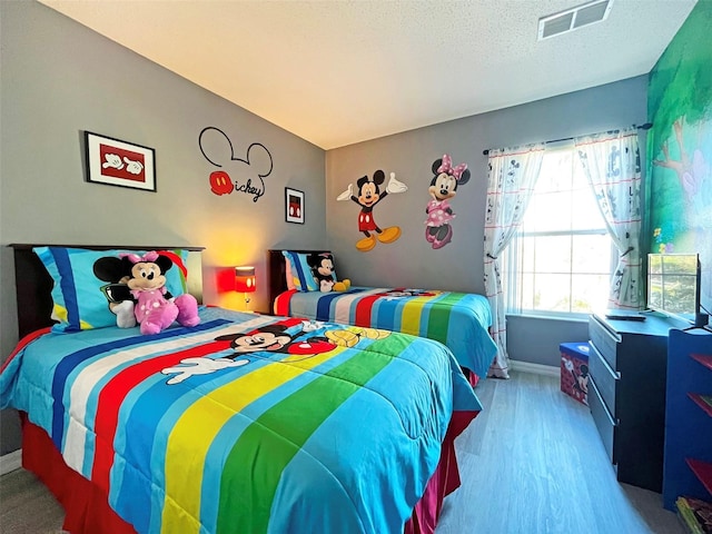 bedroom featuring a textured ceiling and light hardwood / wood-style floors