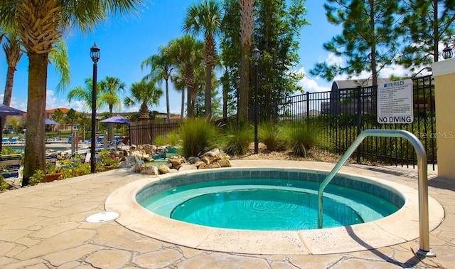 view of pool with a hot tub