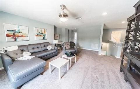 living room featuring carpet and ceiling fan