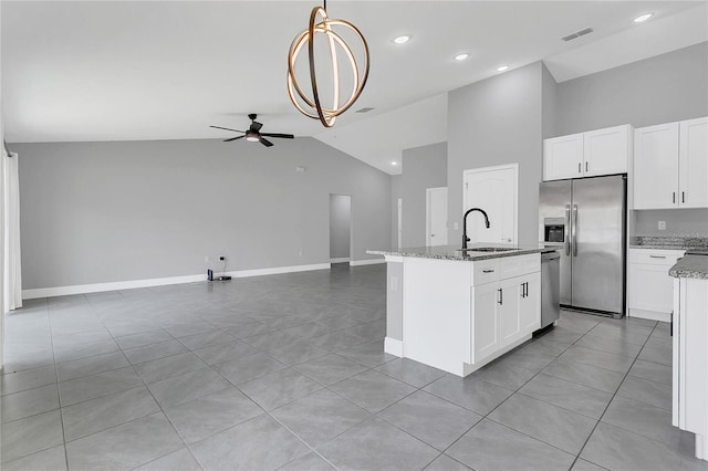 kitchen featuring sink, ceiling fan, light stone countertops, an island with sink, and stainless steel appliances