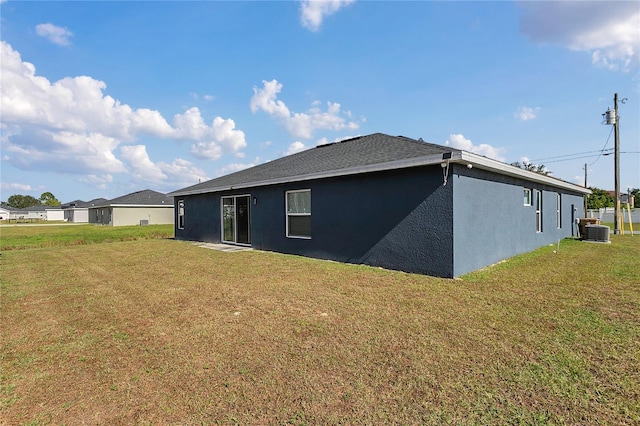 back of property featuring cooling unit and a yard