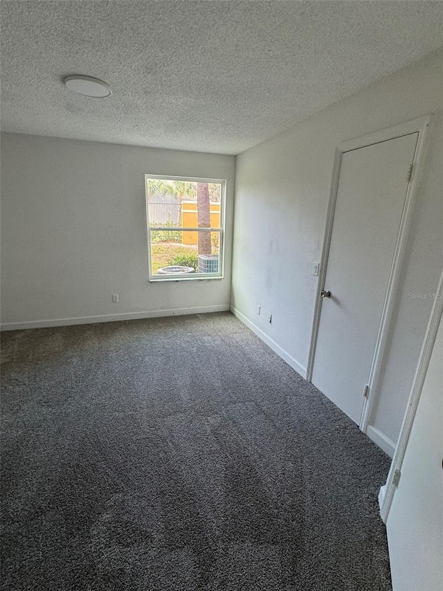 spare room with a textured ceiling and carpet floors