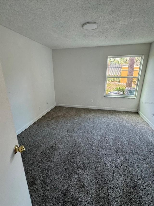 empty room with carpet and a textured ceiling