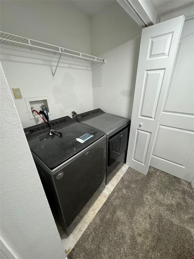 laundry room with washer and dryer and dark colored carpet