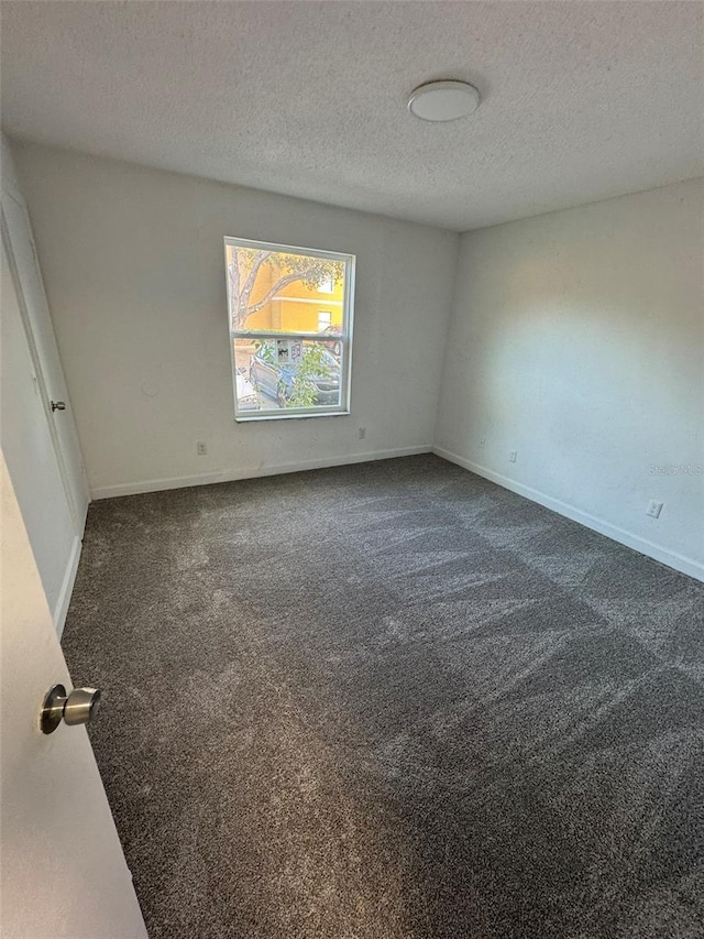 carpeted empty room with a textured ceiling