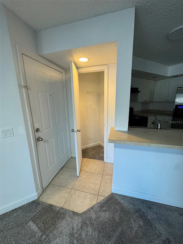 bathroom with tile patterned floors, sink, and a textured ceiling