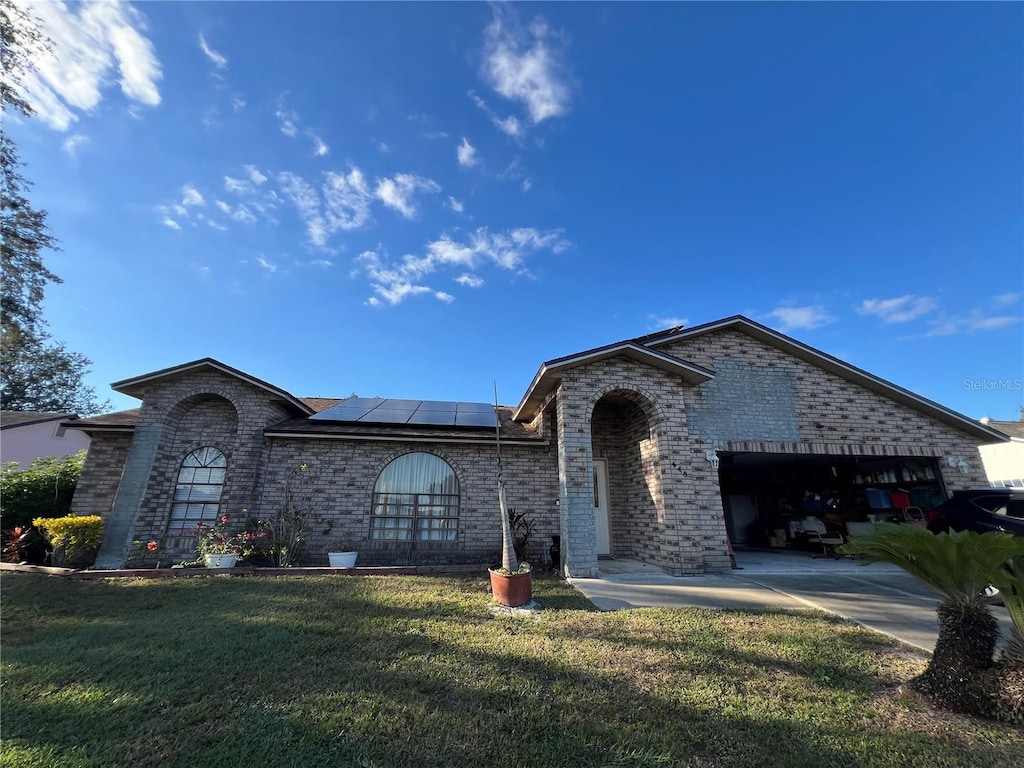 648 Tradewinds Dr, Deltona, FL 32738 - single story home with a front yard, solar panels, and a garage