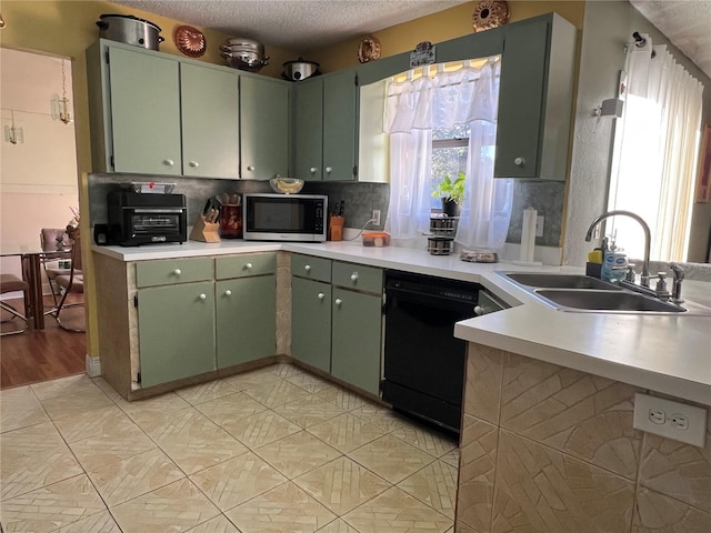 kitchen featuring sink, a healthy amount of sunlight, a textured ceiling, and black dishwasher