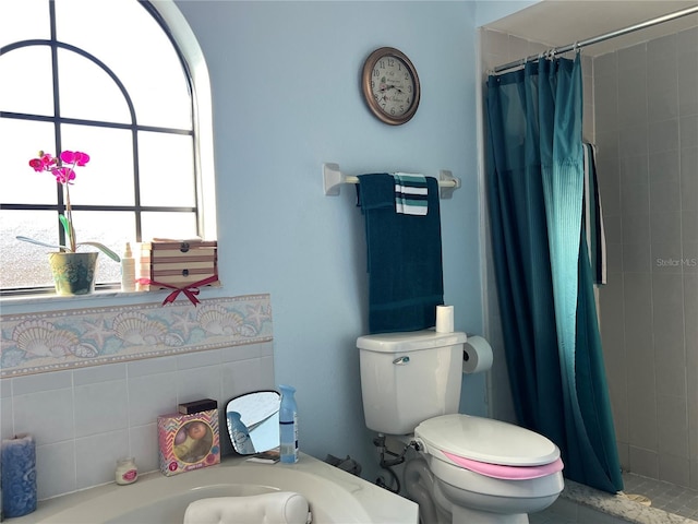 bathroom with a shower with curtain and toilet