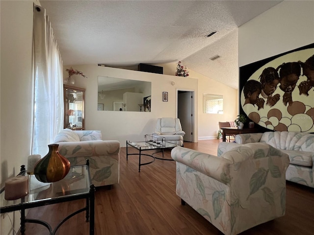 living room featuring wood-type flooring, a textured ceiling, and vaulted ceiling