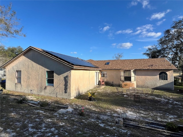 rear view of property with solar panels