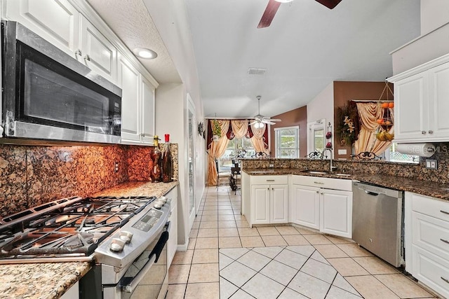 kitchen with white cabinets, sink, appliances with stainless steel finishes, and dark stone counters