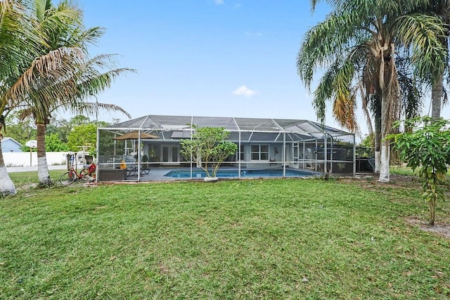 rear view of property featuring a yard, a fenced in pool, and a lanai