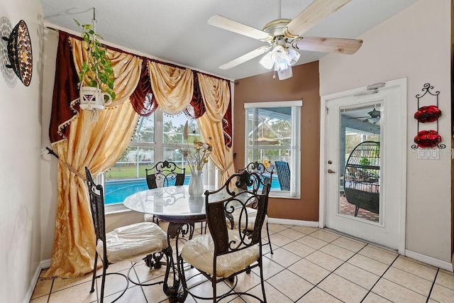 dining space featuring baseboards, a ceiling fan, and light tile patterned flooring