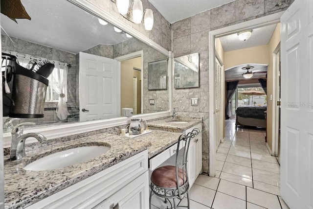 bathroom featuring a sink, tile walls, ensuite bath, and double vanity